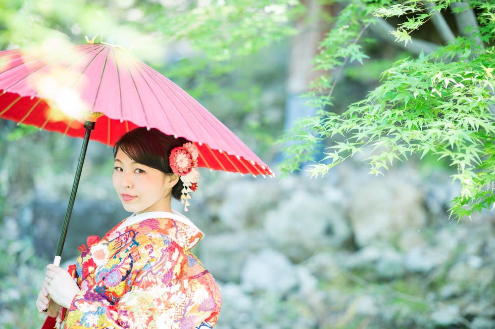 新緑で、赤い和傘を持つ花嫁