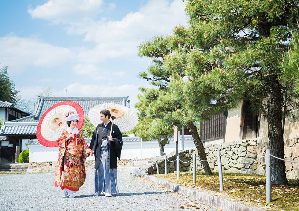 青空広がる仏閣での和装姿の新郎新婦様