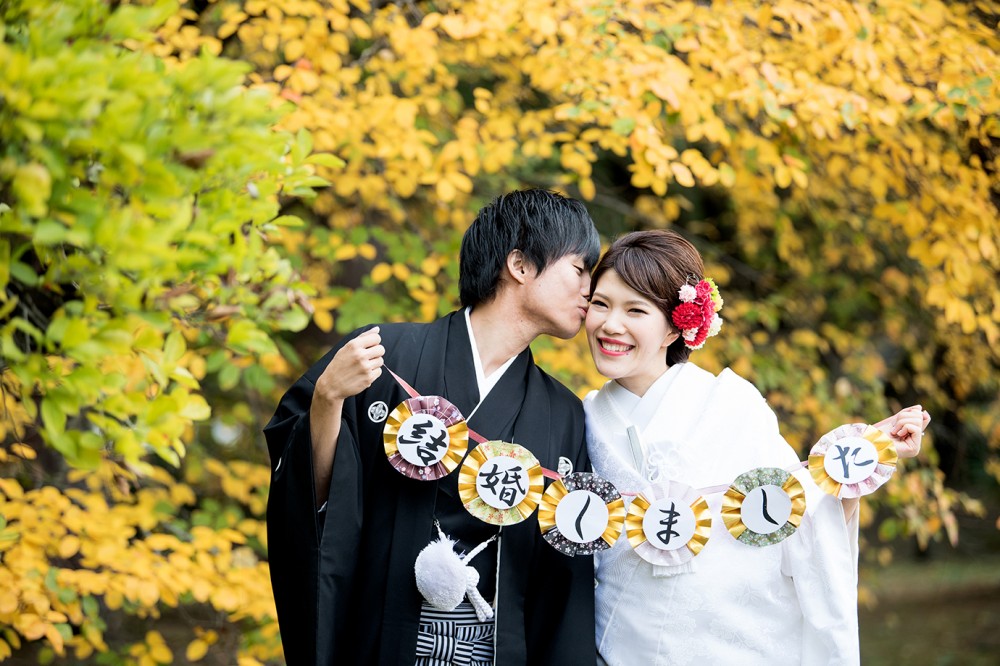 黄色くなった葉っぱの前で、結婚しましたのガーランドを使った写真