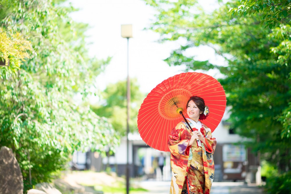 夏の日差し、和傘をさした色打掛姿の花嫁さん。